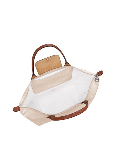Beige handbag with brown leather handles, open to show spacious white interior and a small inner pocket with a snap closure.