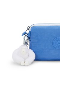 Il portafoglio con zip in tessuto blu presenta un morbido charm a forma di gorilla bianco, accessori in argento e un'etichetta logo testurizzata sulla parte anteriore.