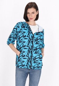 Giacca zip-up blu e nera con motivo a foglie, cappuccio e due tasche laterali; realizzata in tessuto leggero e testurizzato.