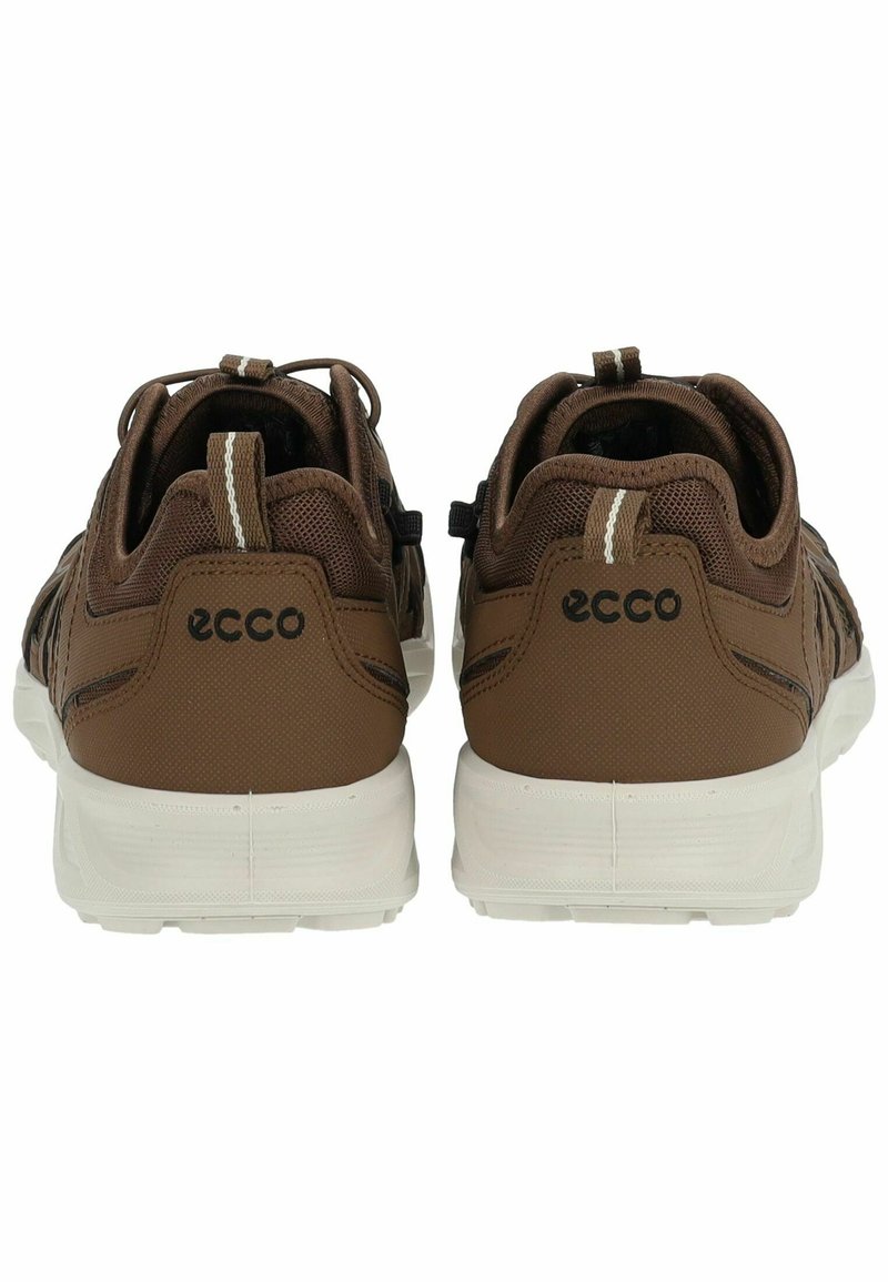 Bruna ECCO-sneakers med en texturerad ovandel, vit sula och kontrasterande beige detaljer. Utrustad med en dragflik och elastiska snören för justering av passform.