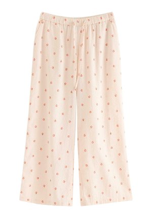 Lichtroze, loszittende broeken met een elastische tailleband, versierd met kleine herhaalde bloemmotieven in oranje- en groentinten.
