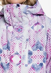 Vícebarevná bunda s geometrickým vzorem v růžových, fialových a modrých odstínech. Má vysoký límec a kapsu na zip na hrudi.