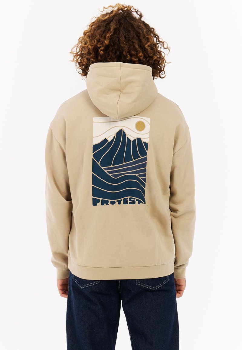 Beige hoodie met een grafische print van gestileerde bergen en golven in marineblauw en crème, met de tekst "PROTEST" onderaan. Gemaakt van een katoenmix.