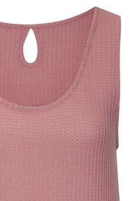 Roza barvna brezrokavna majica z teksturirano, rebrasto vzorčasto; ima ključavnico na hrbtni strani izreza.