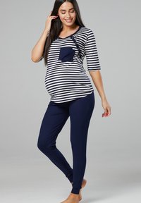 Navy and white striped maternity top with three-quarter sleeves and front pocket, paired with solid navy leggings, smooth fabric.