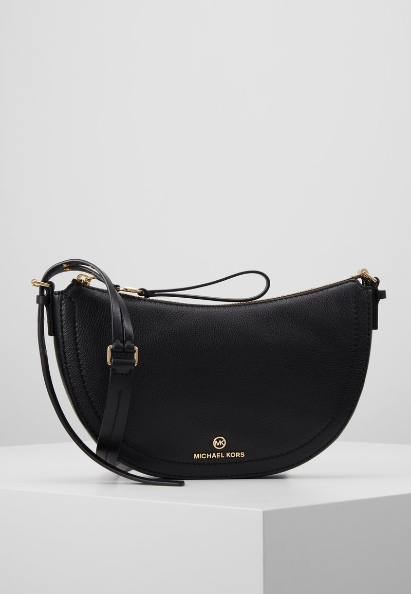 Bolso cruzado de cuero negro con forma curva, con herrajes dorados y un logotipo en la parte delantera. Correa ajustable, superficie texturizada.