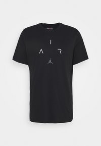 Černé bavlněné tričko s krátkým rukávem, na přední straně s bílým nápisem "AIR" a šedým logem Jordan. Hladká textura, kulatý výstřih.