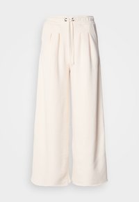 Pantaloni largi de culoare crem, realizați dintr-un material moale, cu talie elastică prevăzută cu șnur și pliuri frontale pentru o formă suplimentară.