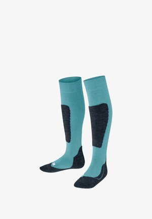 Skarpety do kolan w kolorze turkusowym z ciemnoszarymi wzmocnieniami. Zostały zaprojektowane z myślą o komforcie, mają prążkowany górny brzeg i dopasowany krój.