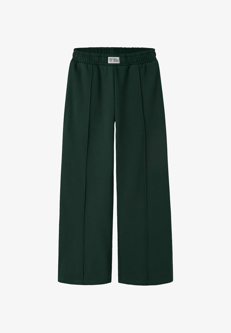 Pantalon vert foncé à jambes larges avec taille élastique et plis devant, avec une petite étiquette rectangulaire au centre devant.