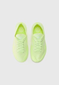 Lime green Nike sneakers with mesh upper, flat laces, and white logo accents. Features a textured surface and cushioned insoles.