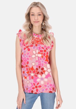 Ärmelloses Top mit Blumenmuster in Rosa, Rot und Weiß; hat einen Rüschenkragen und weichen Stoff mit lockerer Passform.