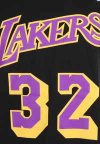 Camiseta negra con la palabra "LAKERS" en negrita púrpura con contornos amarillos y el número "32" en grande púrpura con acentos amarillos.