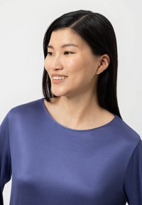 Paarse langemouwen top met een gladde textuur en ronde halslijn, met een ontspannen pasvorm en een licht reflecterende afwerking.