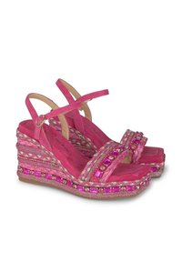Sandales compensées roses avec une texture en daim doux, présentent des accents tressés, des gemmes décoratives et des brides de cheville ajustables.