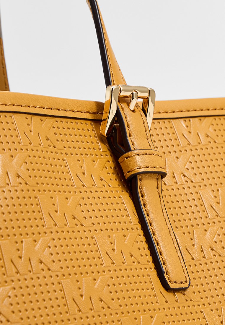 Gelbe Leder-Tasche mit MK-Logo-Textur, ausgestattet mit einer goldfarbenen Schnalle und schwarzem Besatz. Glatte Oberfläche mit einem perforierten Design.