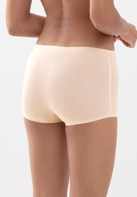 Kastanjaväriset bomullsboyshorts med en mjuk textur, låg midja och sömlös design, som visar minimal hårdvara och rena linjer.