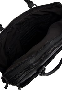 Schwarze Lederhandtasche mit Innentasche mit Reißverschluss und Kartenfächern, ausgestattet mit einem weichen Stofffutter und dezentem Branding auf dem inneren Etikett.