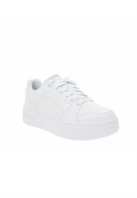 Sneaker bianco con tomaia in pelle testurizzata, punteggiatura sulla punta, lacci piatti e una spessa suola bianca con scanalature per la trazione.