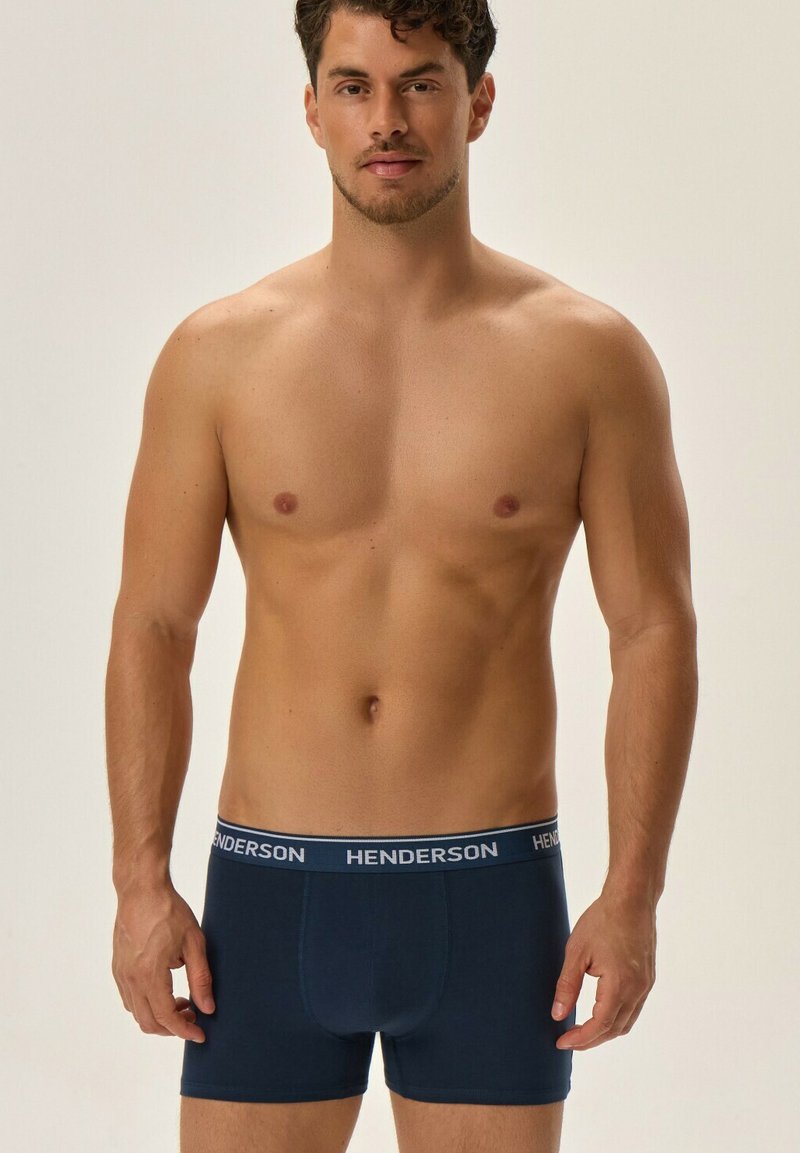 Granatowe bokserki z miękkiego materiału, z elastycznym paskiem w logo oraz dopasowanym krojem. Gładka faktura, długość w połowie uda.