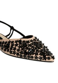 Bailarinas de punta afilada en tela nude, adornadas con flores de lentejuelas negras, con una tira negra en el tobillo y una suela plana para mayor comodidad.