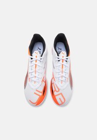 White athletic shoes with orange and black accents. Features a breathable mesh upper, textured patterns, and a cushioned sole for support.