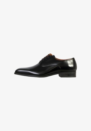 Chaussure Oxford pour homme en cuir noir poli avec laçage fermé, petit talon et bout arrondi lisse, vue de côté.