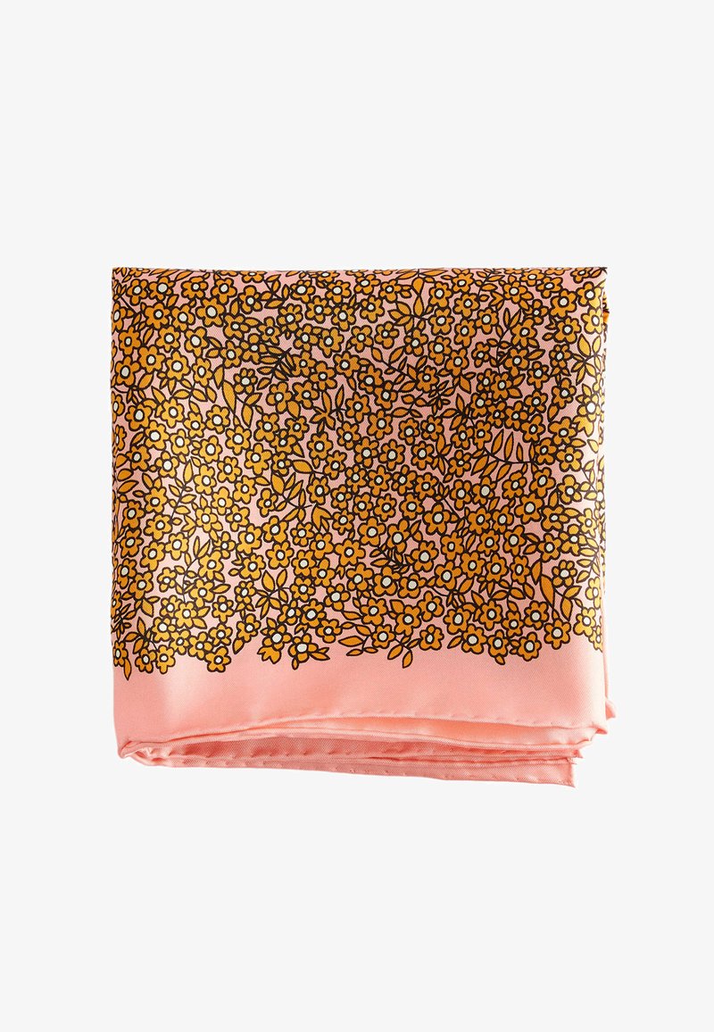 Foulard carré en soie rose avec un motif dense de petites fleurs jaunes et des contours noirs, plié sur un fond blanc.