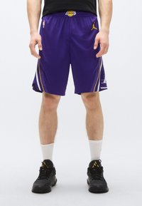 Pantaloni scurți de baschet mov cu accente galbene, având logo-ul Jordan și marca Lakers, confecționați din material respirabil.