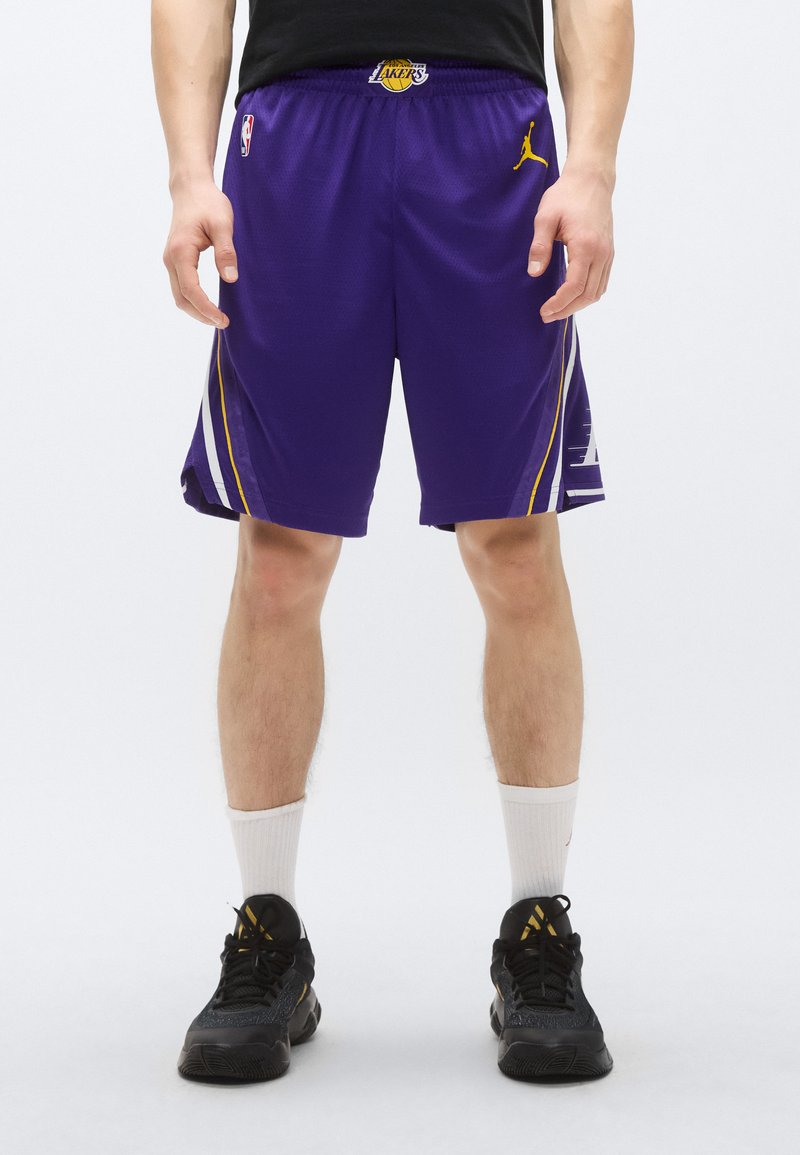 Pantaloni scurți de baschet mov cu accente galbene, având logo-ul Jordan și marca Lakers, confecționați din material respirabil.