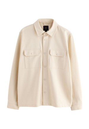 Kermanvärinen pitkähihaisen kauluspaidan takki, jossa on kaulus, kaksi etutaskua läpillä ja napit sekä keskellä oleva napsautettava nappikiinnitys.