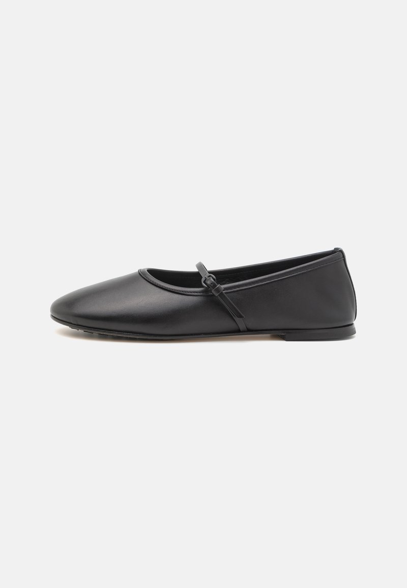 Zapato plano negro con punta redonda, hecho de cuero liso. Presenta una correa delgada a lo largo del empeine y un diseño minimalista.