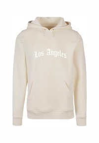Kremfarget hettegenser med lommer foran, med "Los Angeles" i hvit tekst. Materialet ser mykt ut med ribbestrikkede mansjetter og nederkant.