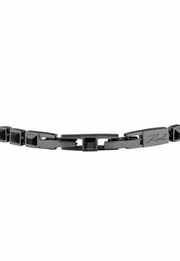 Bracciale nero a maglie con pietre nere squadrate e una chiusura rettangolare incisa con "Karl" in corsivo.