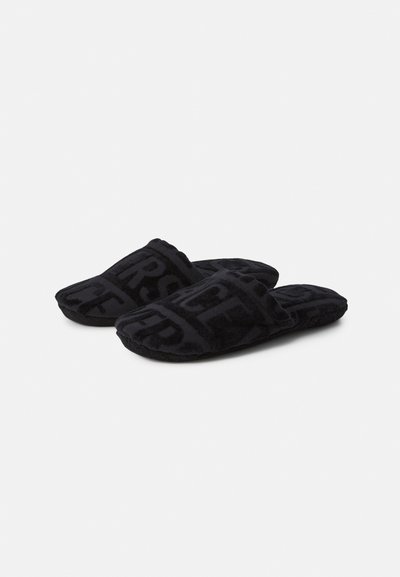 Μαύρα πλυσμένα παντόφλες με απαλή υφή, ανοιχτή σχεδίαση μπροστά και ανάγλυφο γεωμετρικό σχέδιο σε όλη την επιφάνεια.