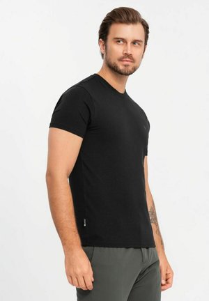 Sort kortærmet T-shirt med rund hals, lavet af blød bomuld. Har et lille logo nær brystet og et mærke på kanten.