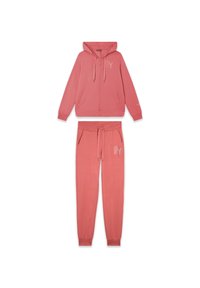 Sudadera rosa y joggers a juego hechos de tela suave. La sudadera con capucha cuenta con un cierre frontal, cordones y detalle de logo. Los pantalones tienen bolsillos y cintura ajustable.