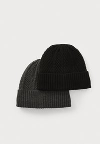 Two knitted beanies: one black with ribbed texture and herringbone pattern, and one dark gray with ribbed hem. Soft wool blend material.
