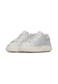 Sneaker bianche con un design perforato, punta rotonda, suola piatta testurizzata e chiusura con lacci. Presentano un logo discreto sulla linguetta e un colletto imbottito.