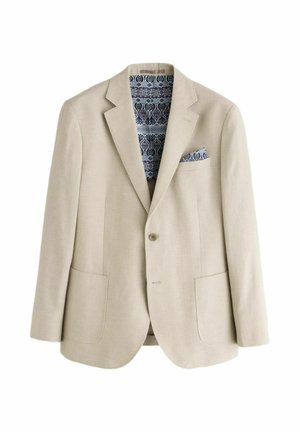 Bēšs vienpogu žakete ar izgrieztiem atlokiem, diviem priekšējiem kabatām un zilas rakstaina kabatas lakatiņa un oderējuma detaļām.