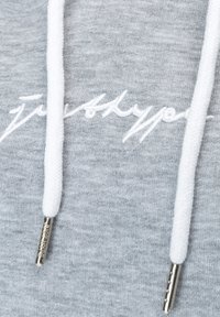 Sudadera gris con una textura suave, con cordones blancos y extremidades de metal, que muestra texto bordado en una fuente cursiva en la parte delantera.