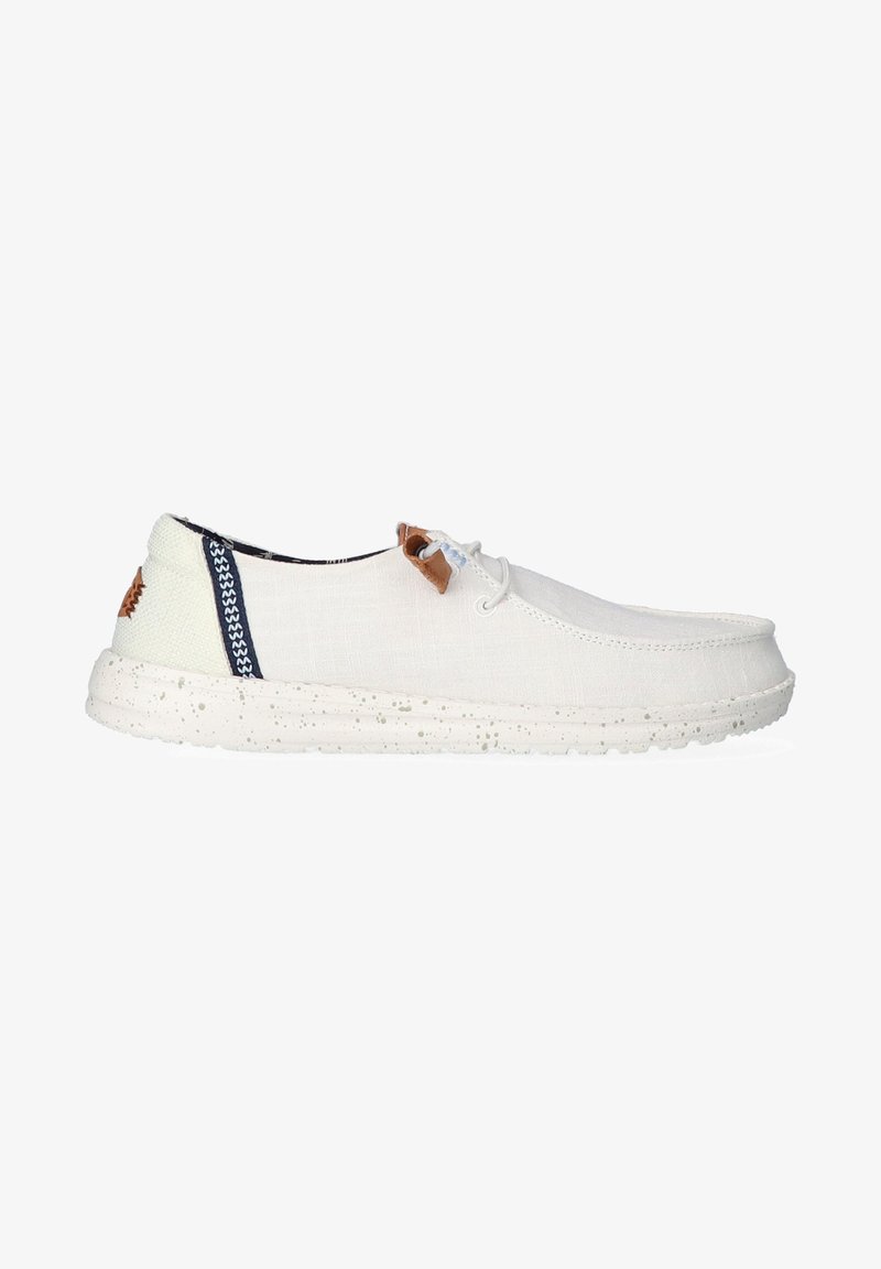 Canvas shoes in off-white with a textured surface and a speckled rubber sole. Features brown leather accents and navy striped detailing.