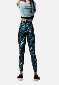 Legginsy z wielokolorowym, falistym wzorem kamuflażu w odcieniach teal, granatowym i białym. Wykonane z elastycznego materiału, z wysokim stanem i bocznymi kieszeniami.