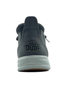 Sneaker grigio scuro con tomaia texturizzata, lacci elastici e logo visibile sul tallone. Presenta una suola bianca e marrone.