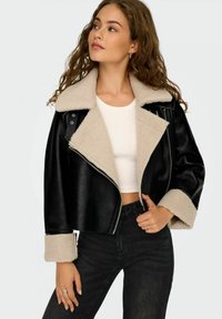 Giacca corta nera in ecopelle con colletto e polsini in shearling beige, caratterizzata da una cerniera diagonale e una texture liscia.