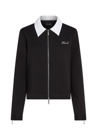 Čierna bunda na zips s kontrastným bielym golierom, so slim fit strihom a vyšívaným logom na ľavej hrudi. Hladká textura.