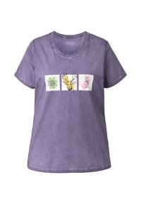 Camiseta de algodón morada que presenta tres estampados cuadrados con ilustraciones de una flor, un ciervo y un conejo rosa, contorneados con acentos negros.