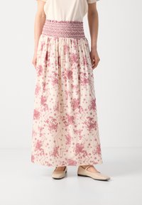 Maxi skirt with a smocked pink waistband, featuring a cream base and detailed floral and geometric patterns in shades of pink.