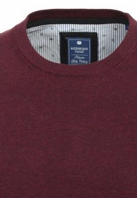 Bordowy sweter z okrągłym dekoltem, teksturowany, z paskowanym wnętrzem i metką w kolorze niebiesko-białym. Prosty design, bez wzorów.