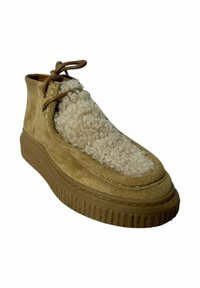 Bota de ante color tan hasta el tobillo con un panel suave de forro polar, punta redonda y suela de goma texturizada. Cordones en la parte delantera para un ajuste seguro.